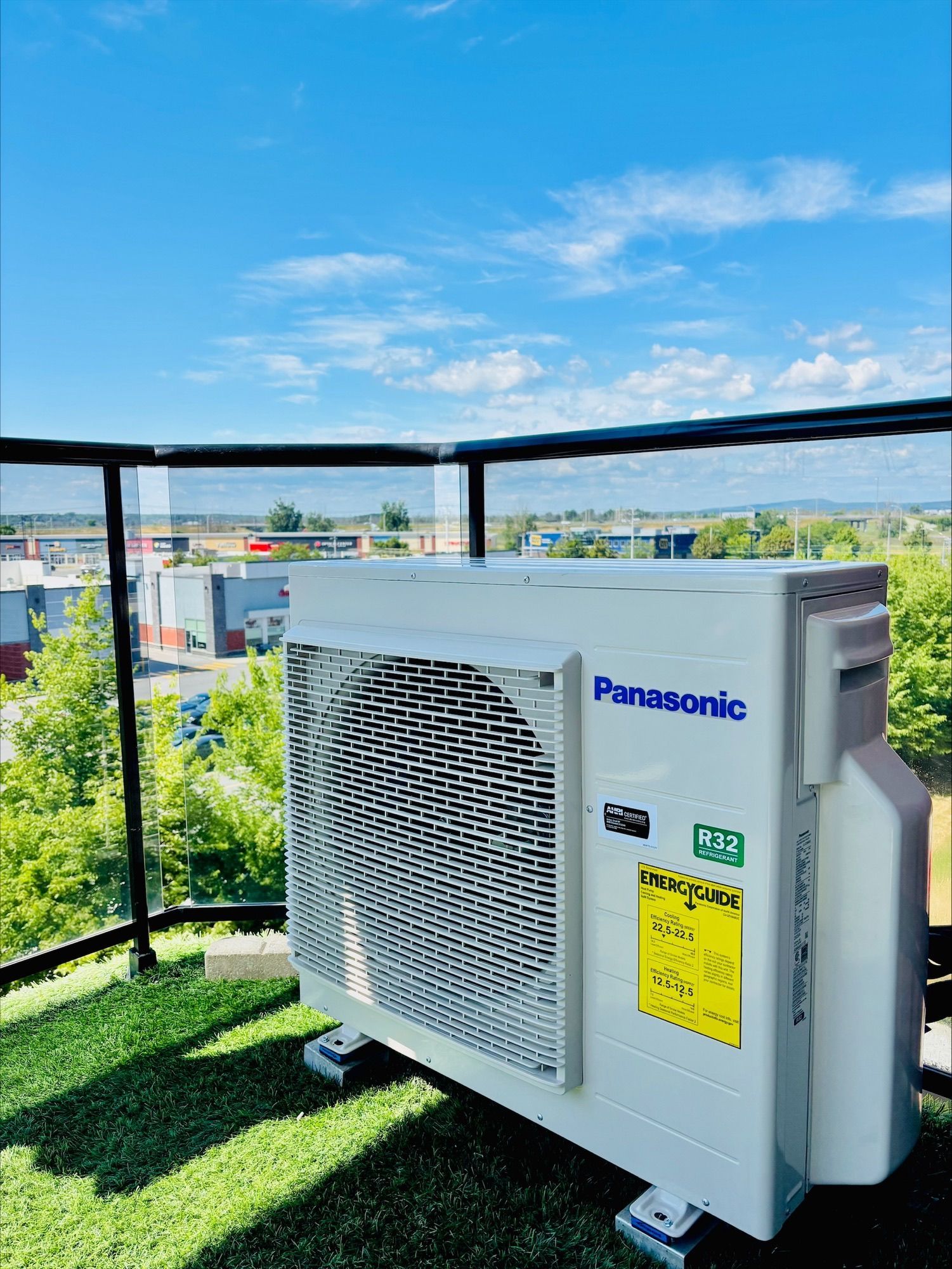 Unité de climatisation Panasonic sur un toit, avec un ciel bleu en arrière-plan.