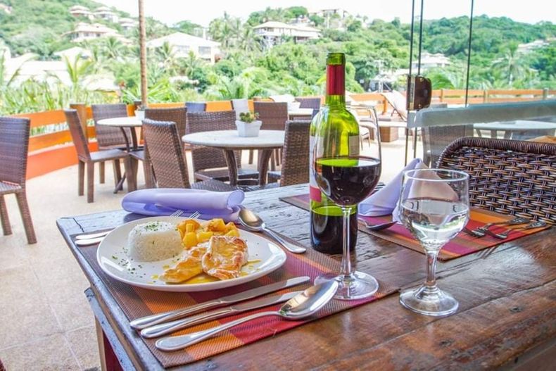 Café da manhã: pratos de comida, suco, xícaras de café sobre uma mesa de madeira.