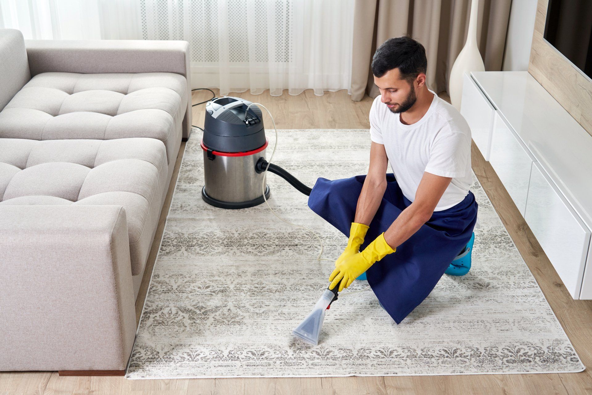 Man Cleaning Carpet In The Living Room — Bryan, OH — Sammons Carpet Care Man Cleaning Carpet In The Living Room — Bryan, OH — Sammons Carpet Care