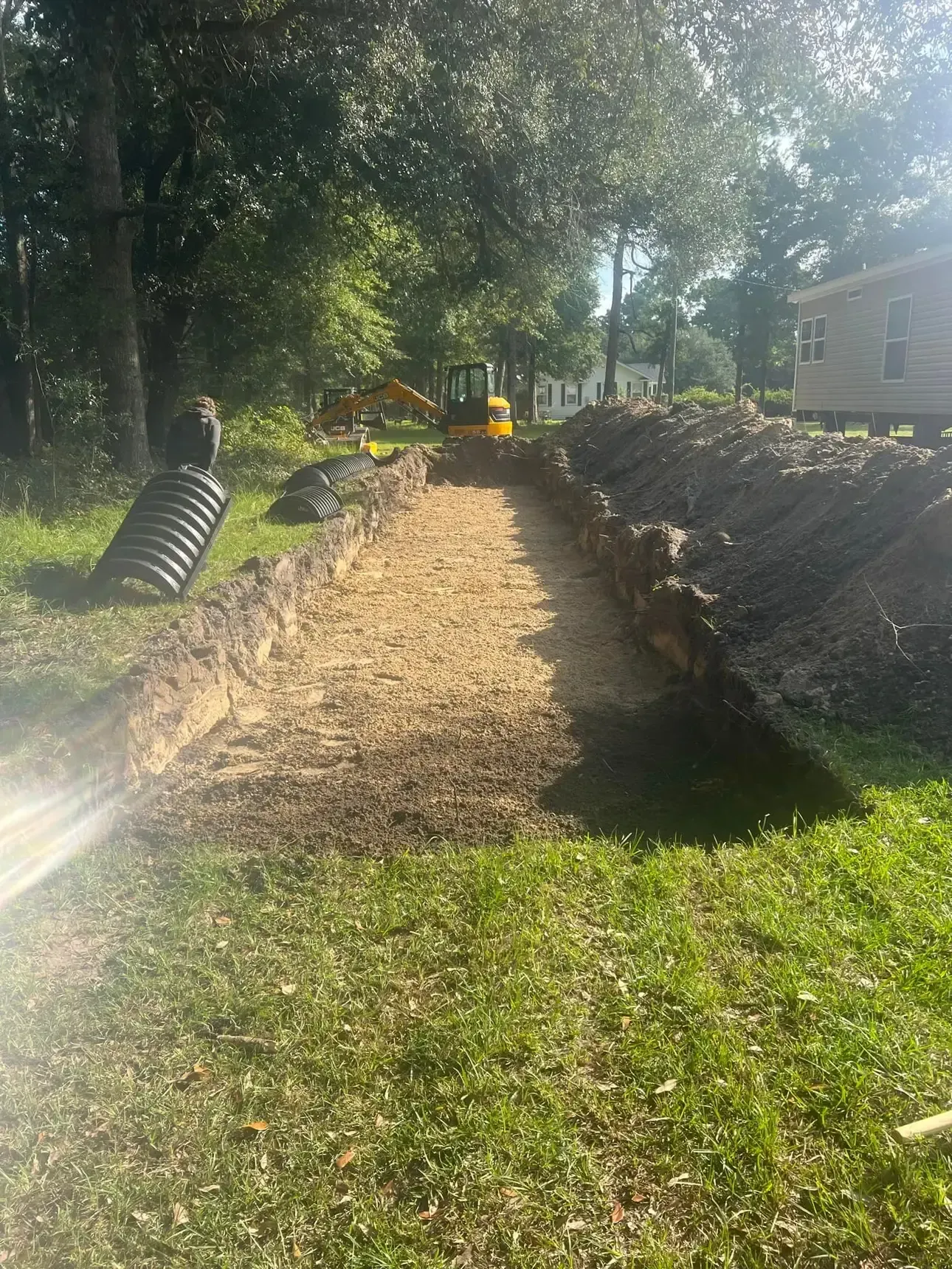 A large pile of dirt is sitting in the middle of a grassy field.