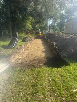 A large pile of dirt is sitting in the middle of a grassy field.