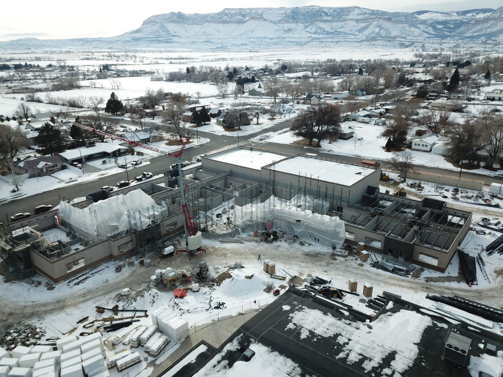 An aerial view of a building under construction in the snow.