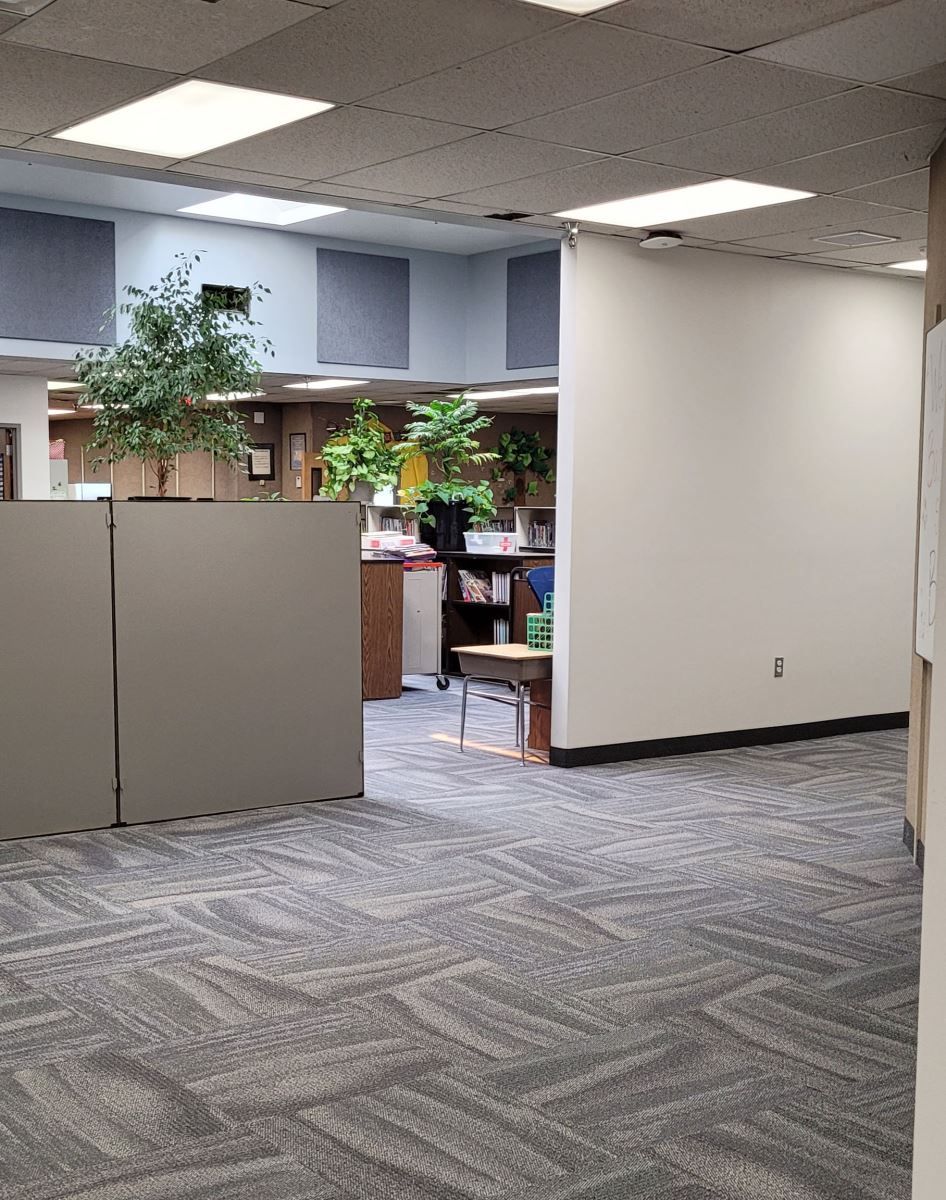 An empty office with a carpeted floor and cubicles