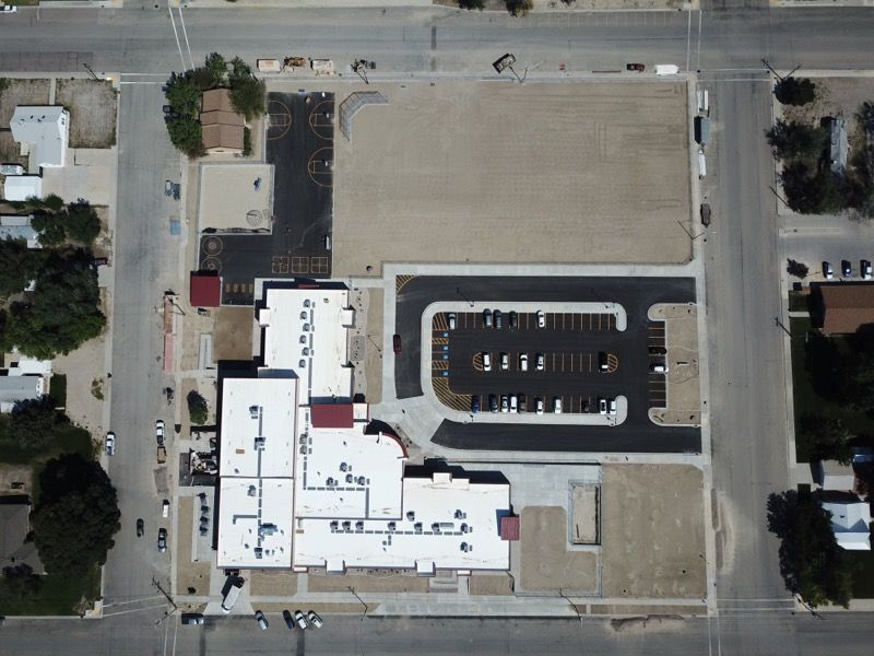 An aerial view of a large building with a white roof