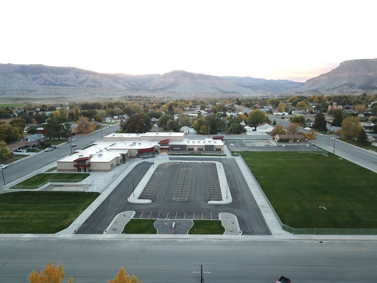 An aerial view of a school with mountains in the background.