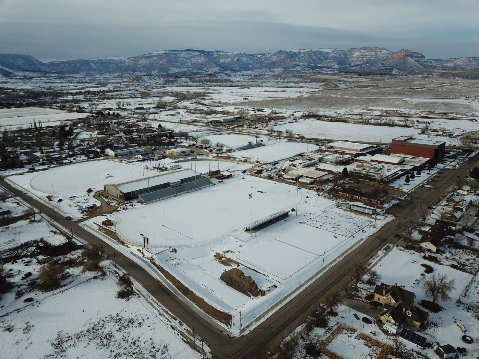 An aerial view of a snowy city with mountains in the background