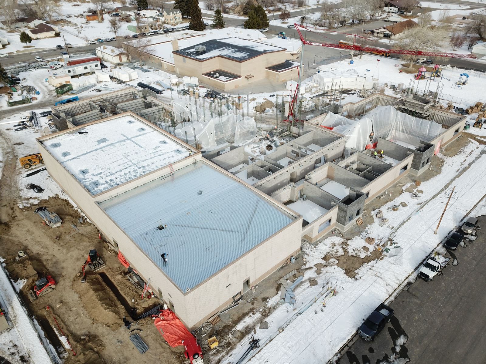 An aerial view of a building under construction in the snow.