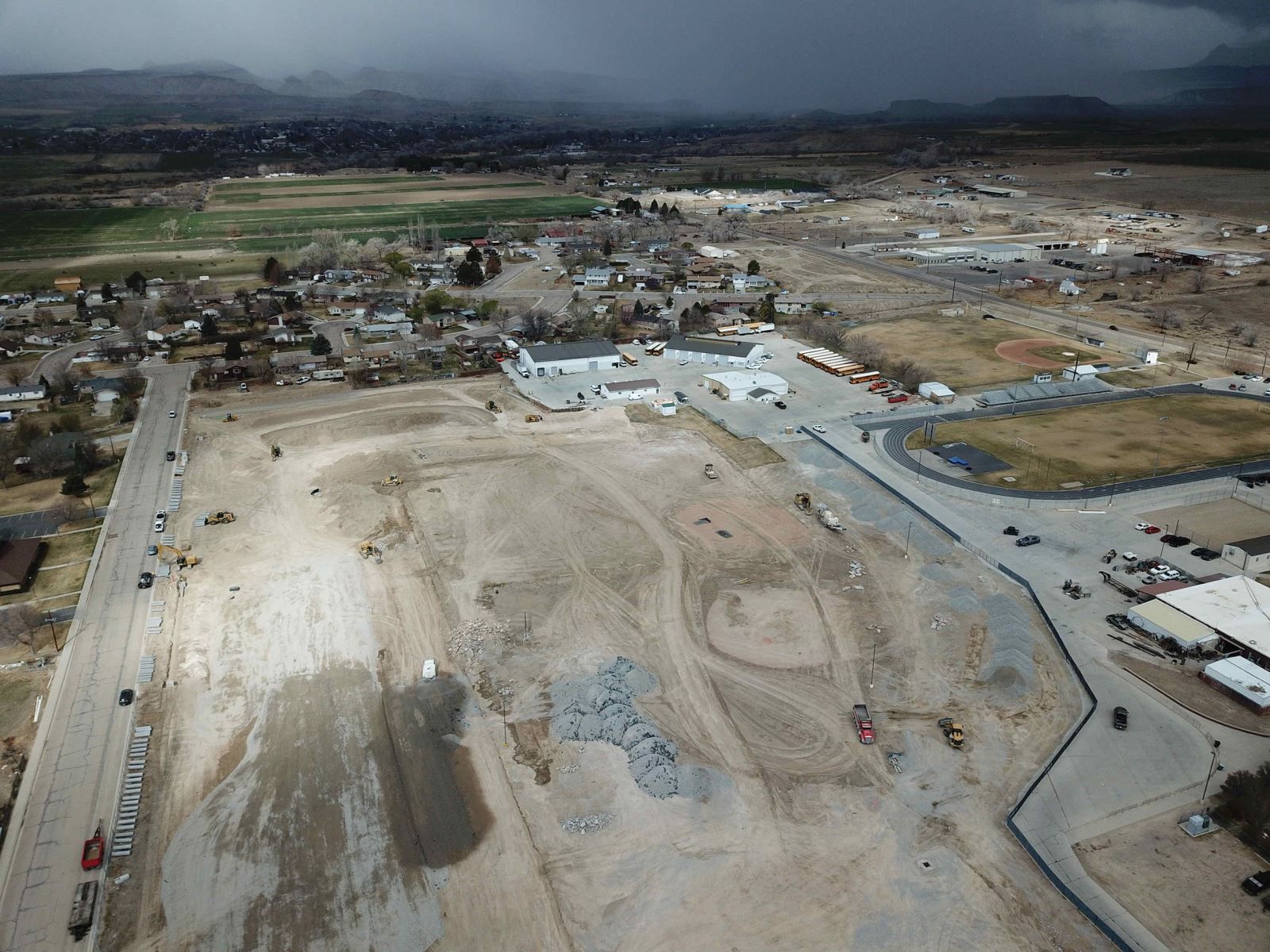 An aerial view of a construction site with mountains in the background.