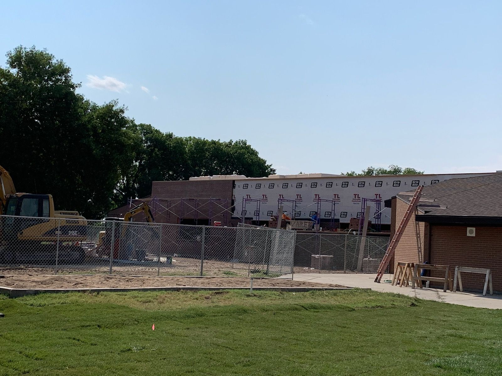 A construction site with a fence and a building under construction