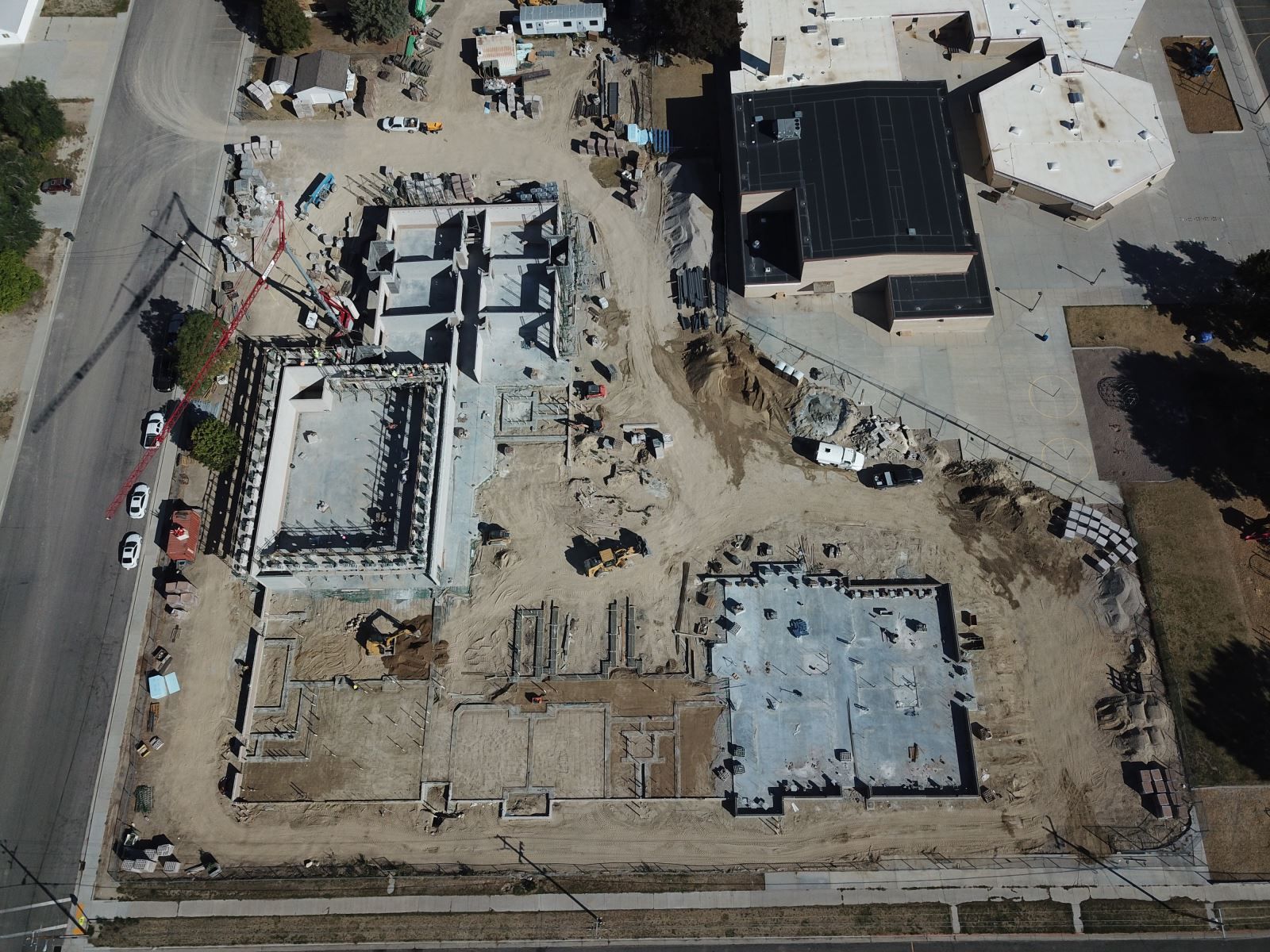 An aerial view of a construction site with a building in the background