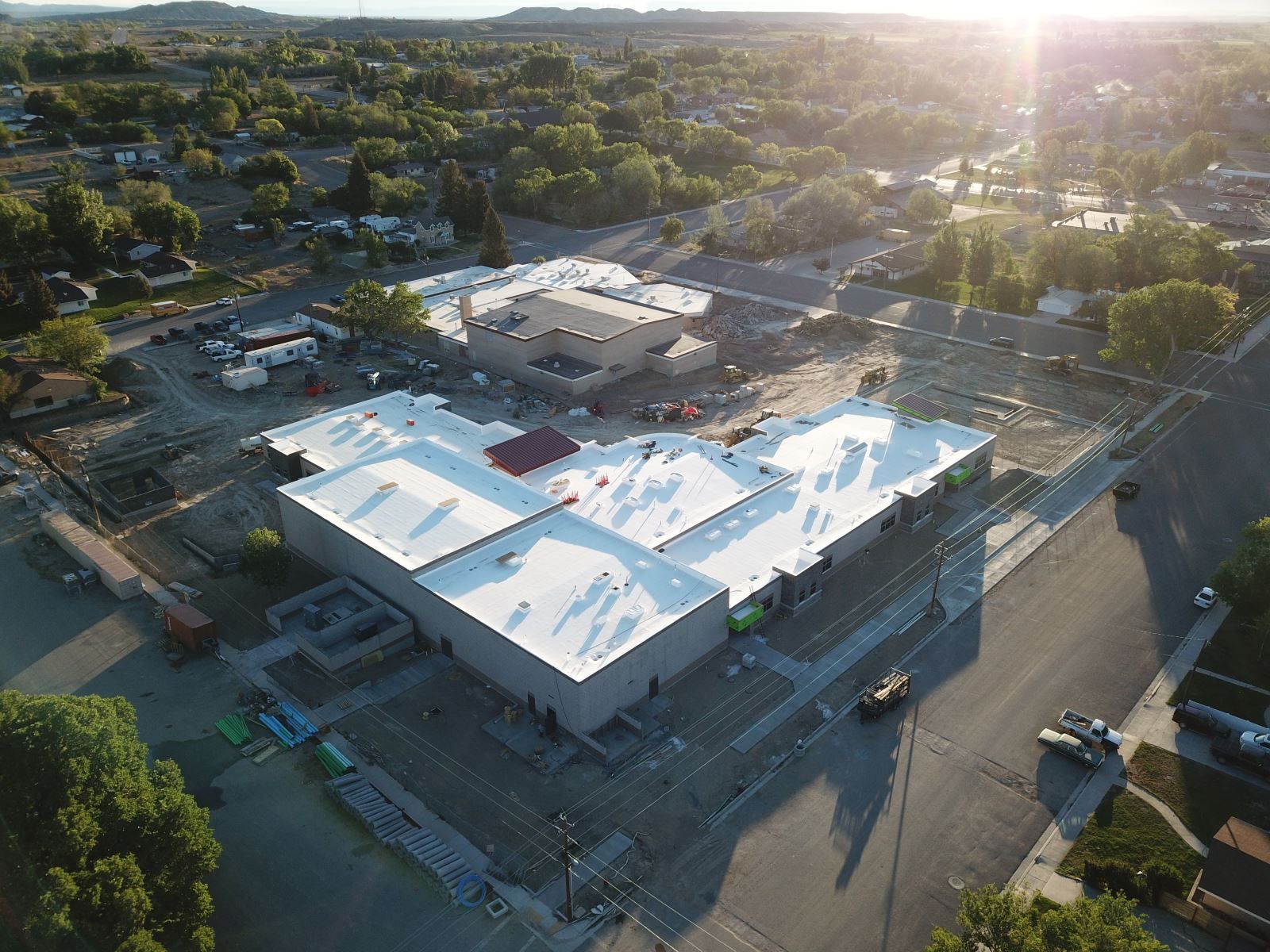 An aerial view of a building under construction with a white roof.