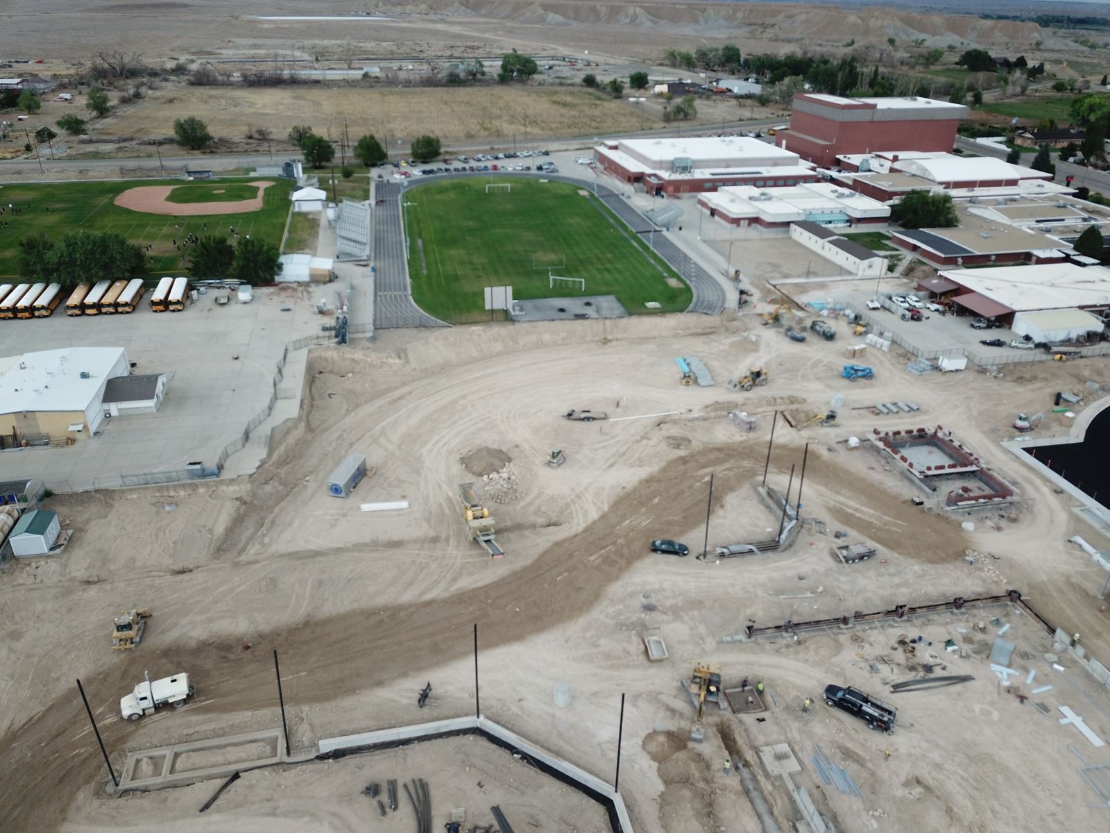 An aerial view of a construction site with a stadium in the background