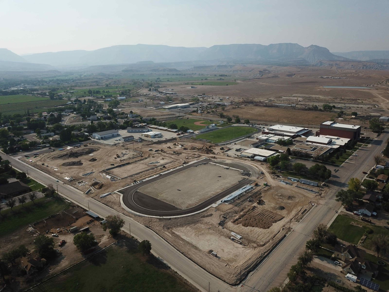 An aerial view of a construction site with mountains in the background.