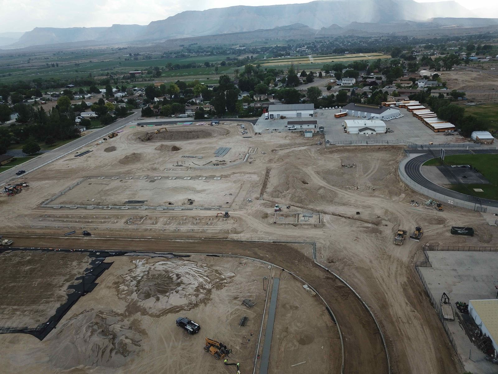 An aerial view of a construction site with mountains in the background.
