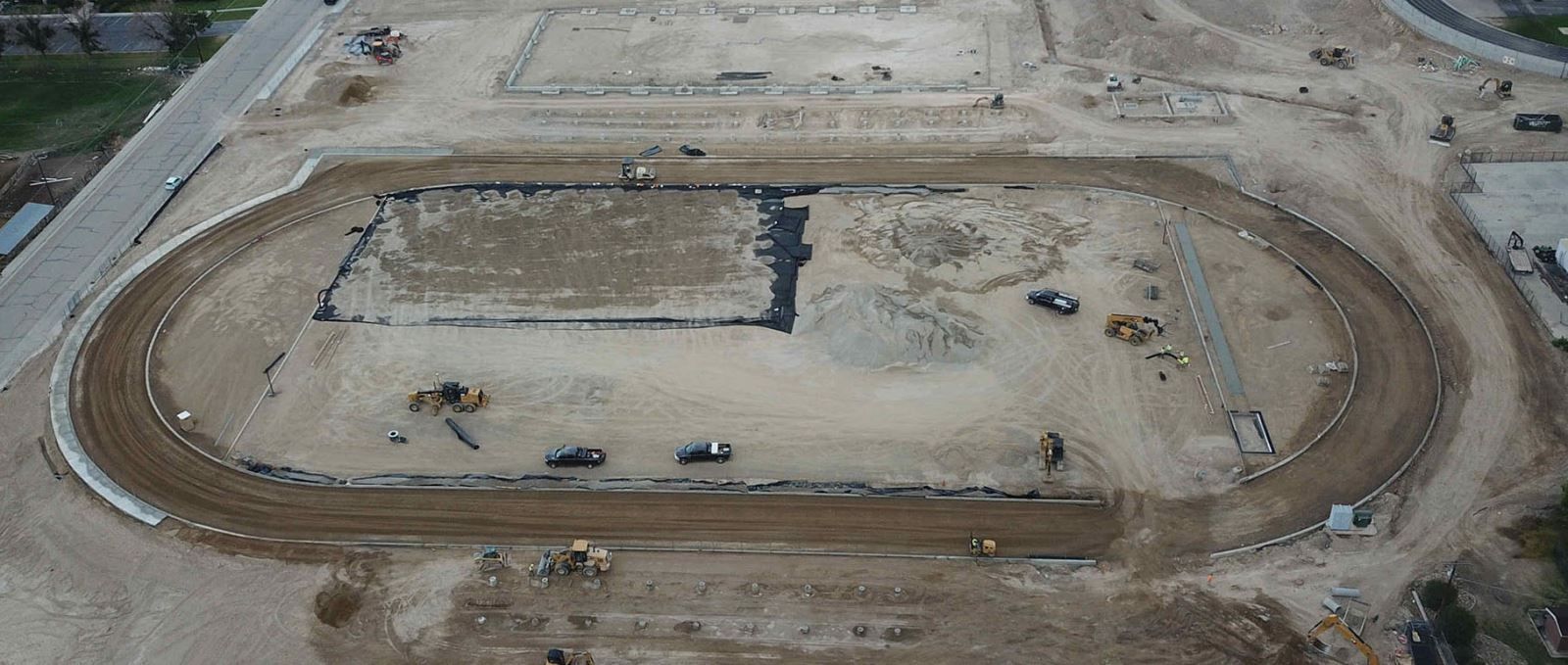 An aerial view of a dirt track under construction.