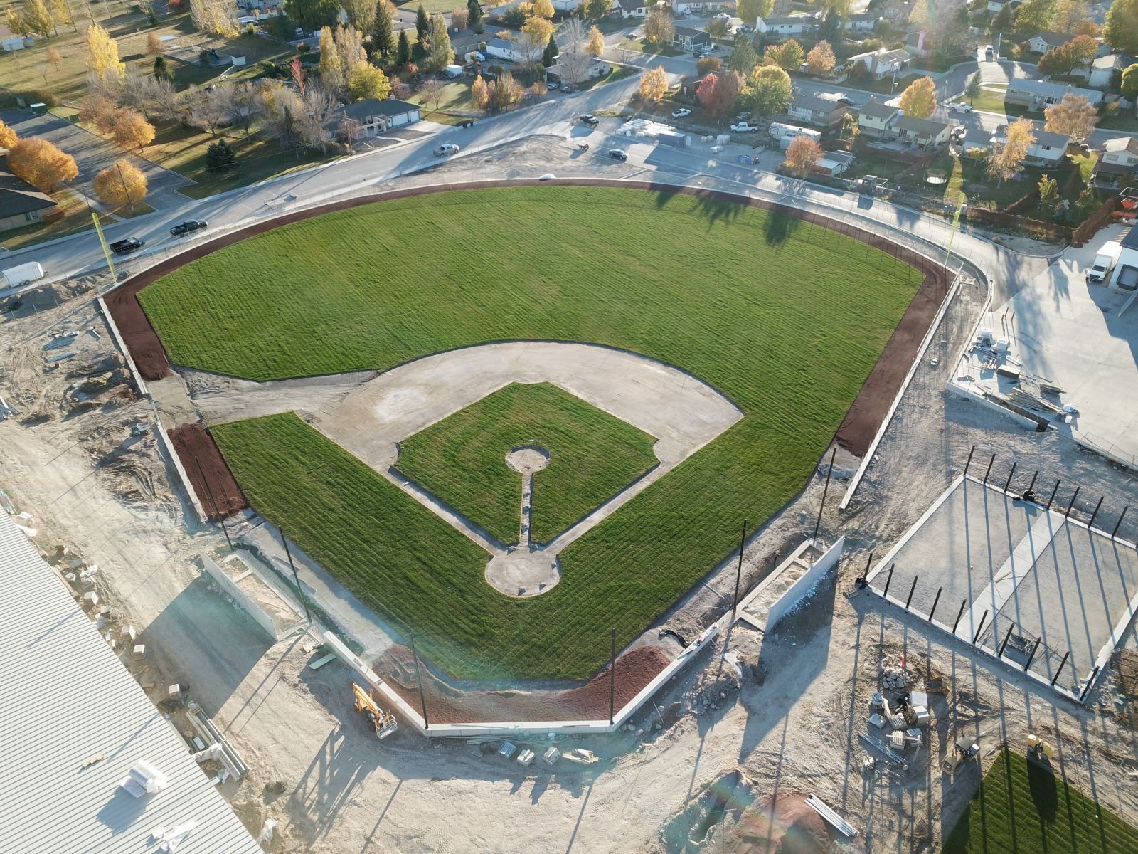 An aerial view of a baseball field in a small town.
