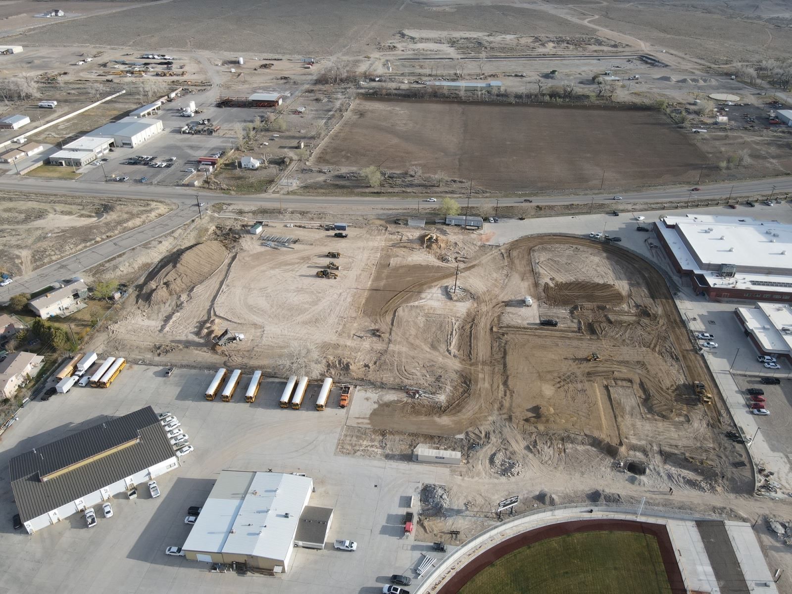 An aerial view of a construction site with a stadium in the background