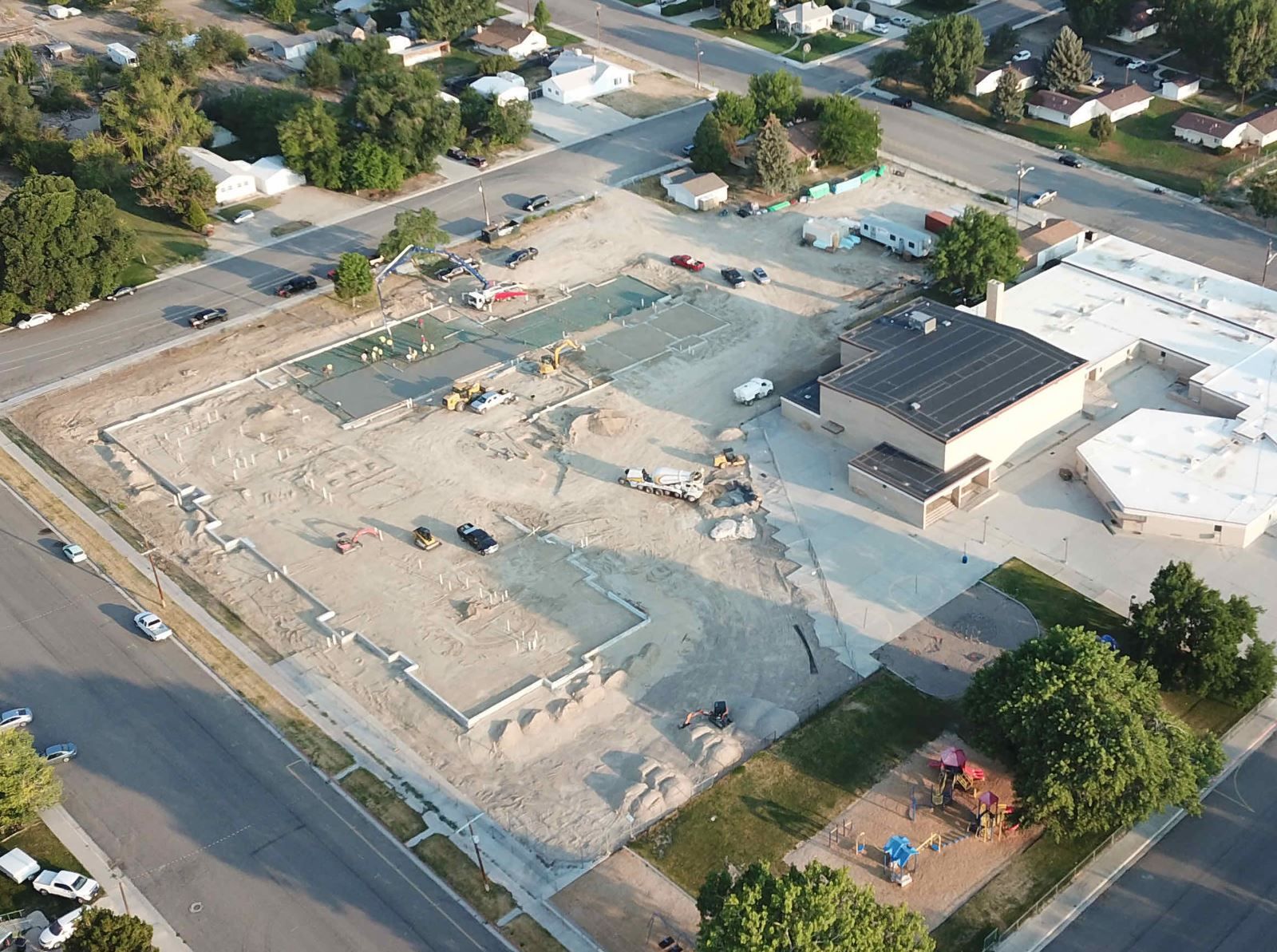 An aerial view of a building under construction in a residential area.