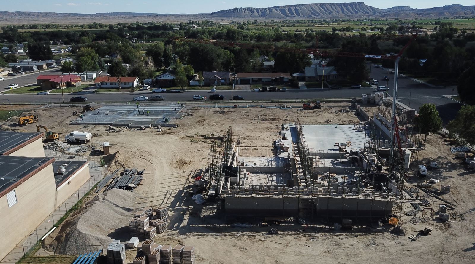 An aerial view of a construction site with mountains in the background