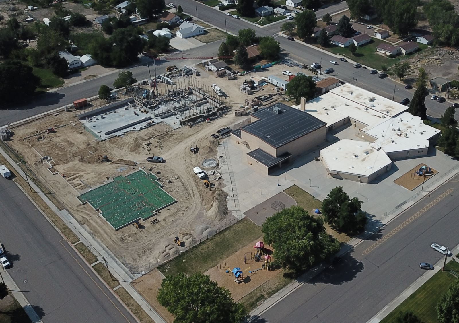 An aerial view of a building under construction and a playground