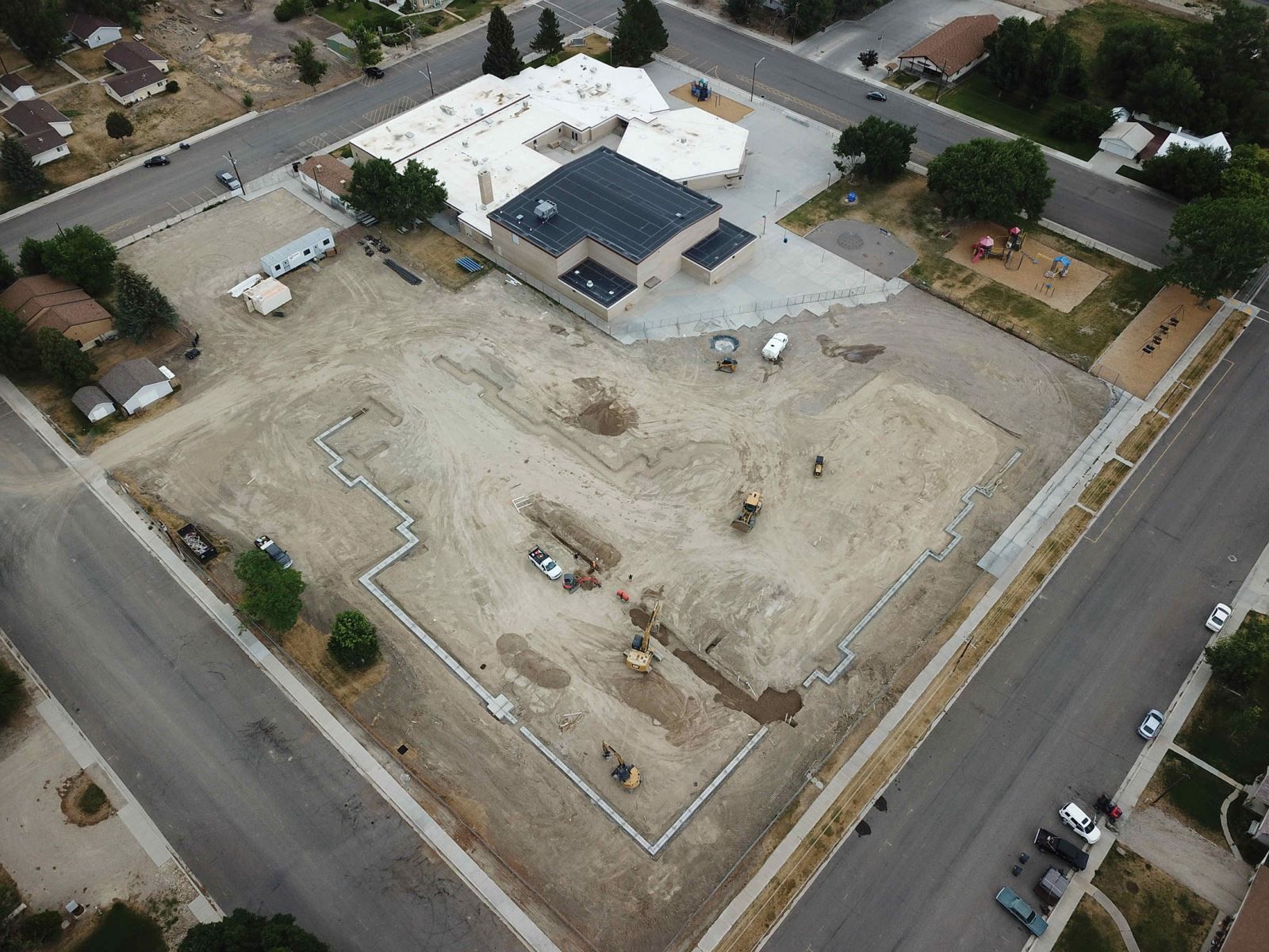 An aerial view of a building under construction in a residential area.