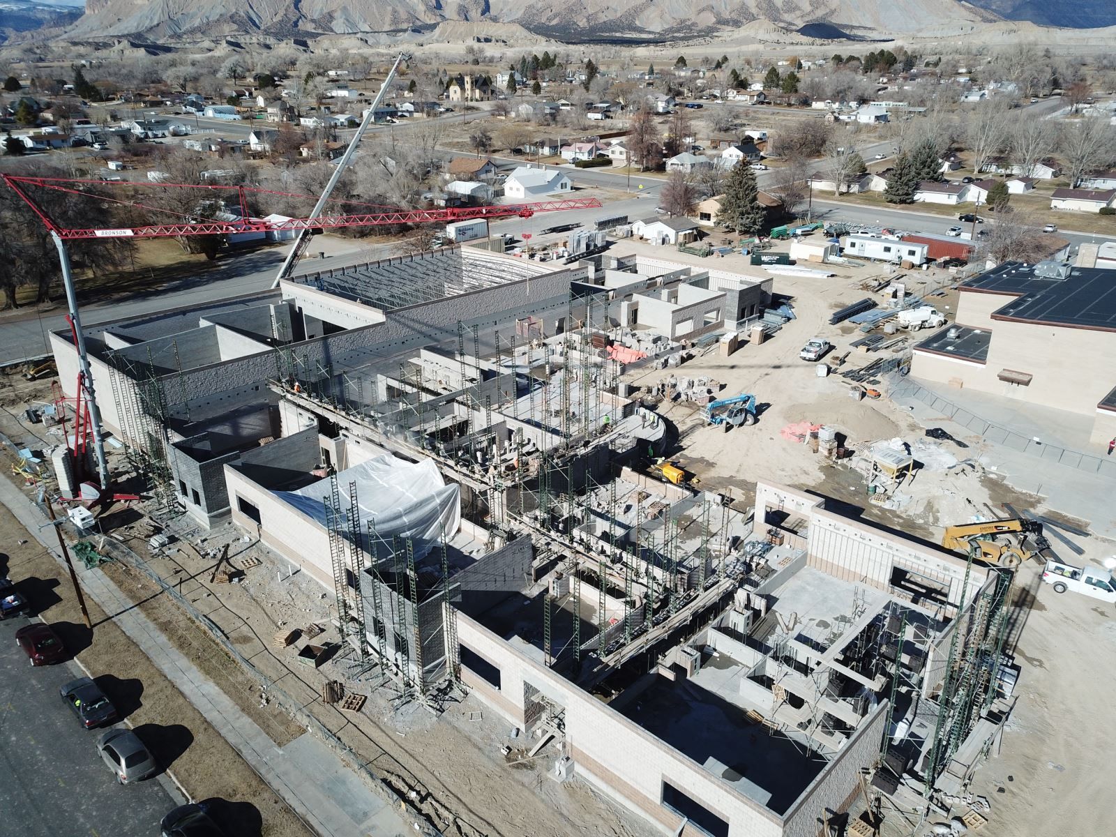 An aerial view of a building under construction with a crane in the background.