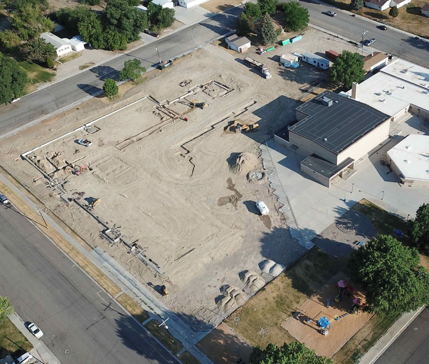 An aerial view of a construction site with a building in the background
