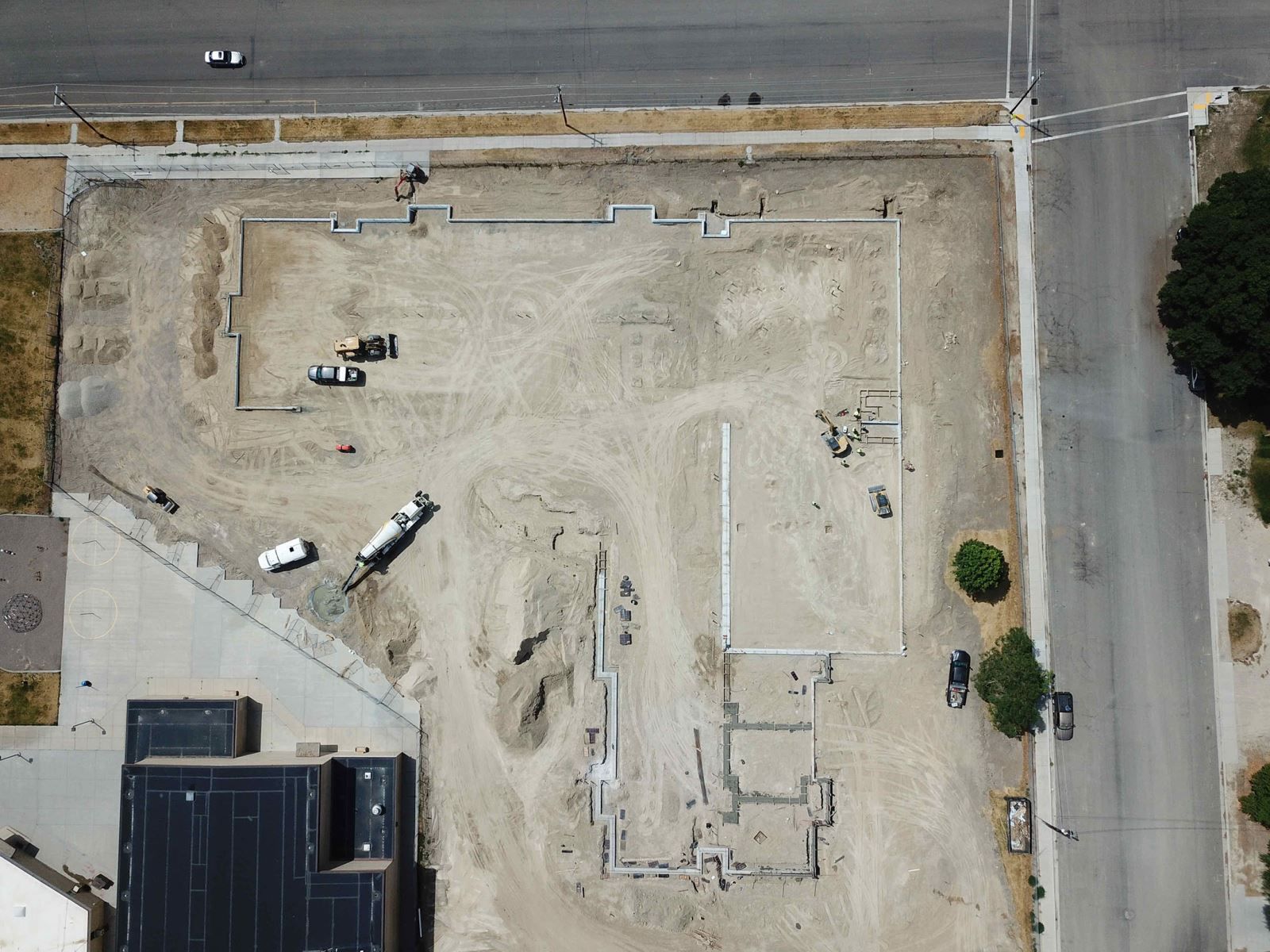 An aerial view of a construction site with a building in the background.
