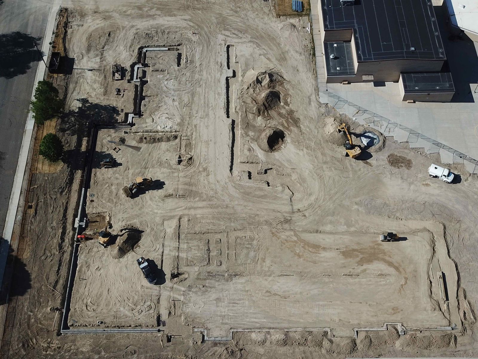An aerial view of a construction site with a building in the background