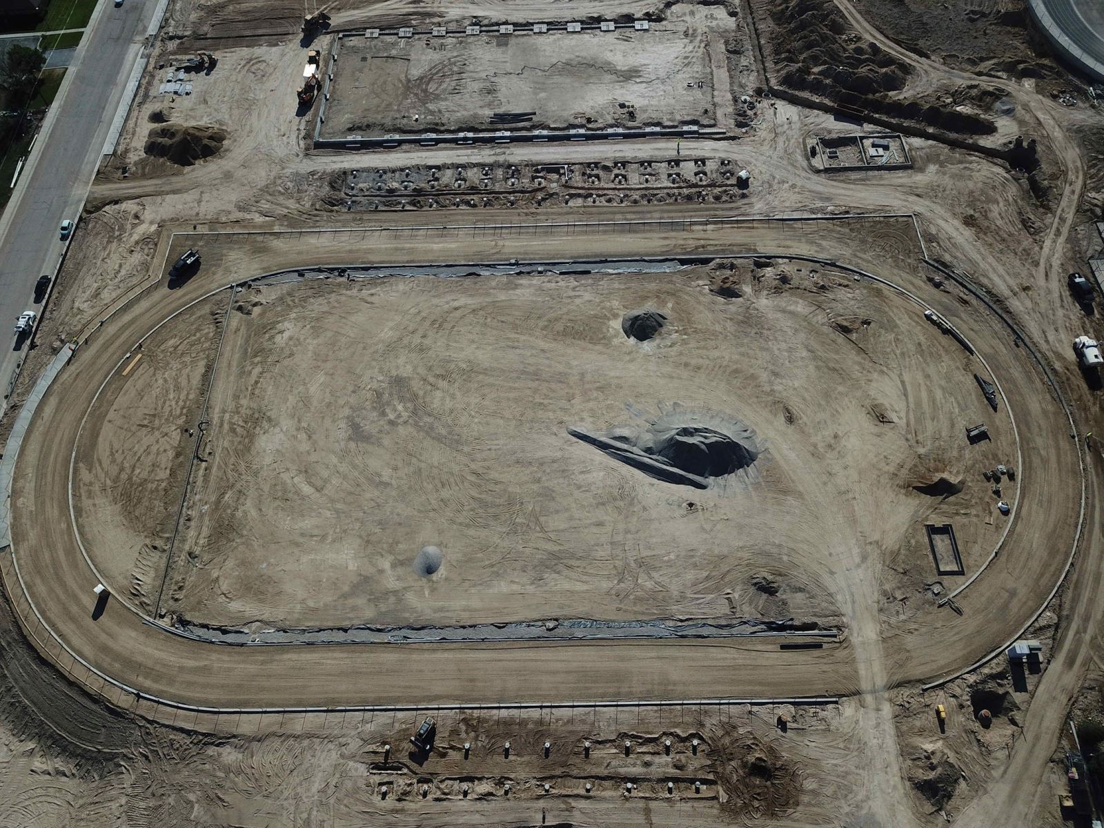 An aerial view of a dirt track with a large hole in the middle.