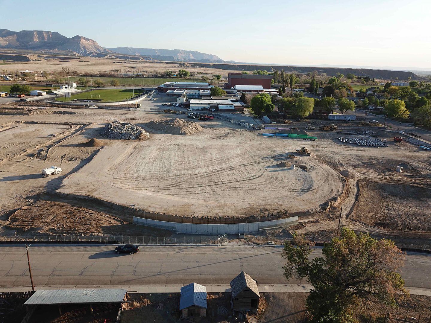 An aerial view of a construction site in the desert with mountains in the background.
