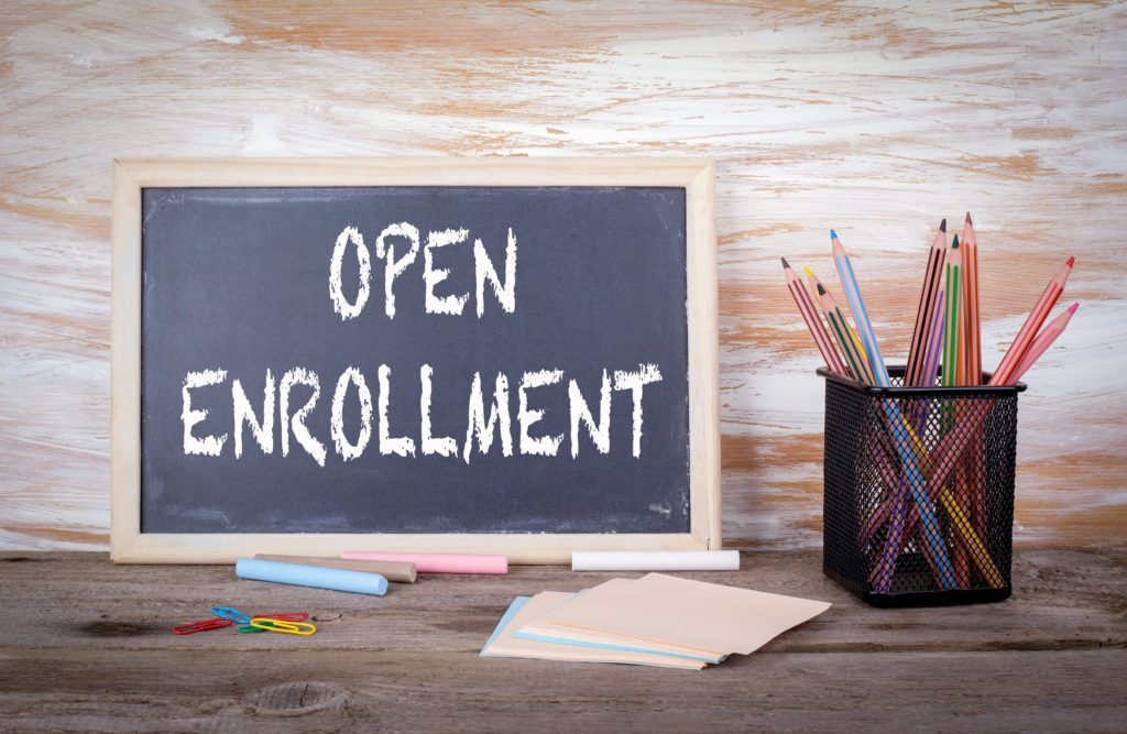 A blackboard with the words open enrollment written on it