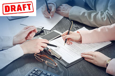 A group of people are sitting at a table signing a document.