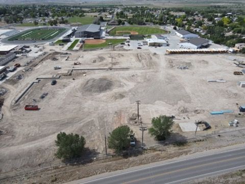 An aerial view of a construction site with a lot of dirt and trees