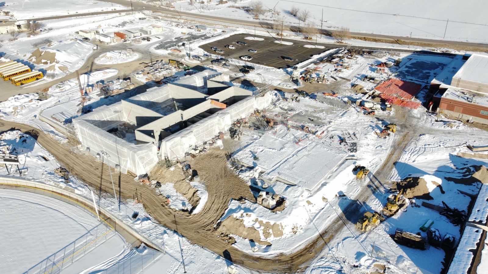 An aerial view of a building under construction in the snow.