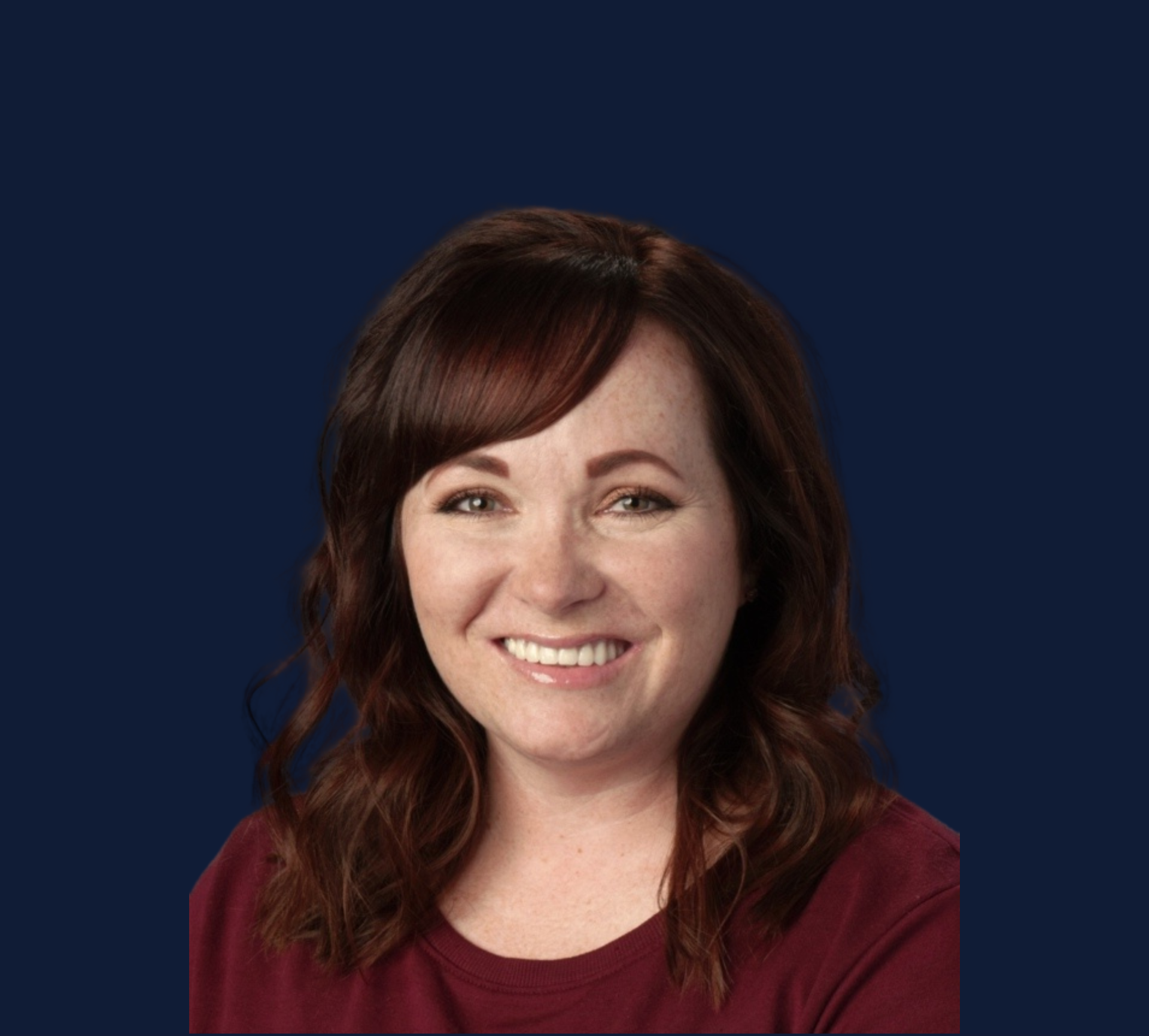 A woman in a red shirt is smiling in front of a blue background.