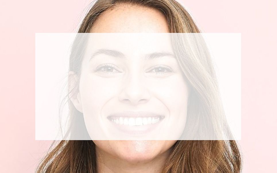 A woman is smiling with a white frame around her face.