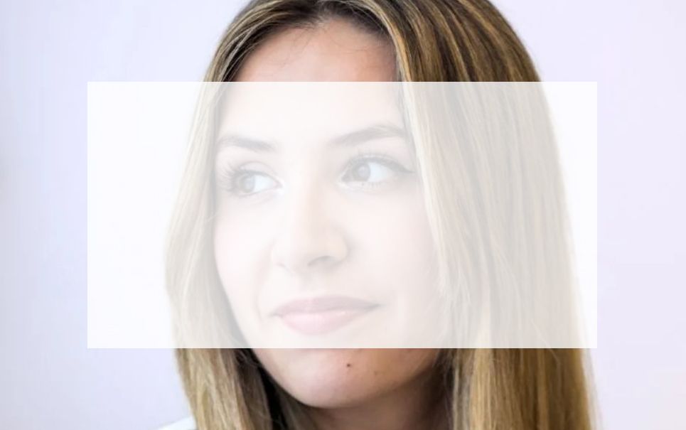 A blurry picture of a woman 's face with a white frame around it.