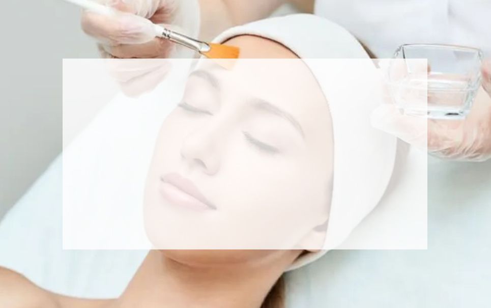 A woman is getting a facial treatment with a brush.