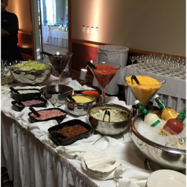Buffet table with salads, desserts, and colorful appetizers in glass bowls and serving dishes