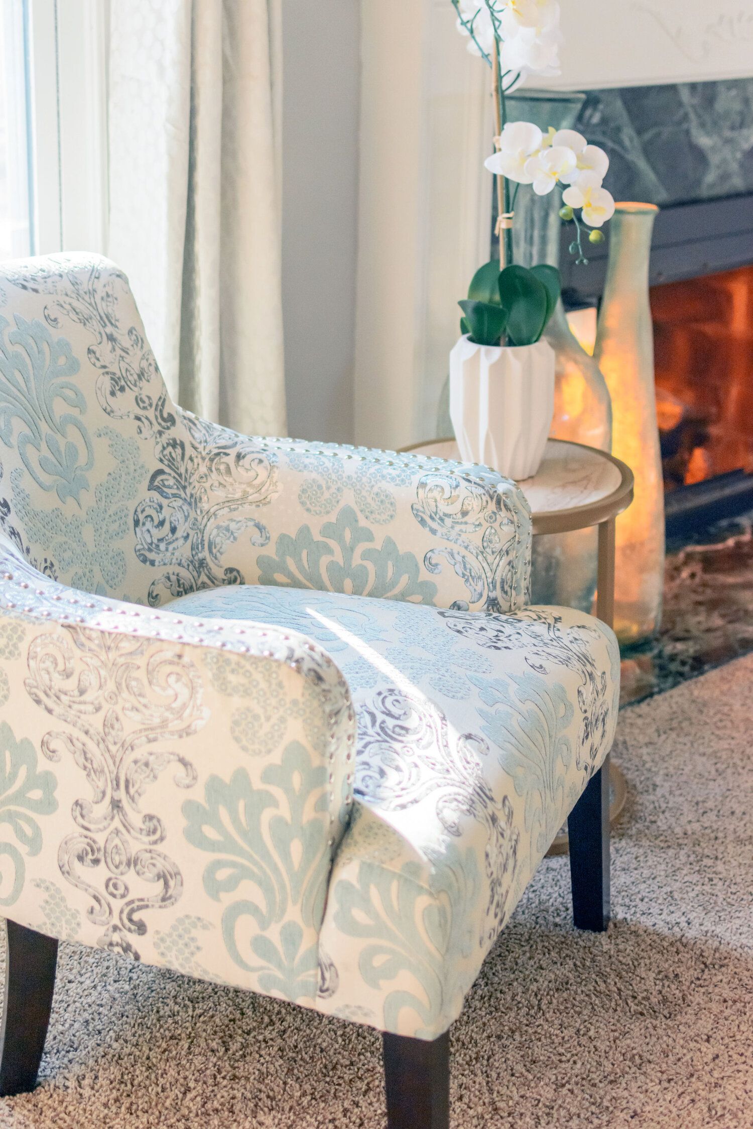 A chair is sitting in front of a fireplace in a living room.