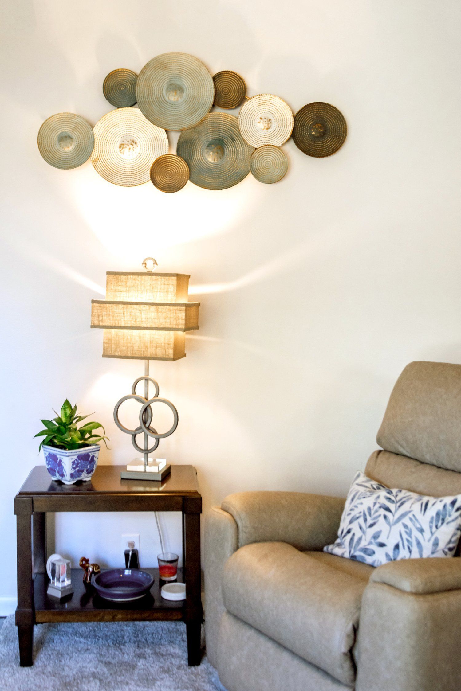A living room with a chair , table and lamp.