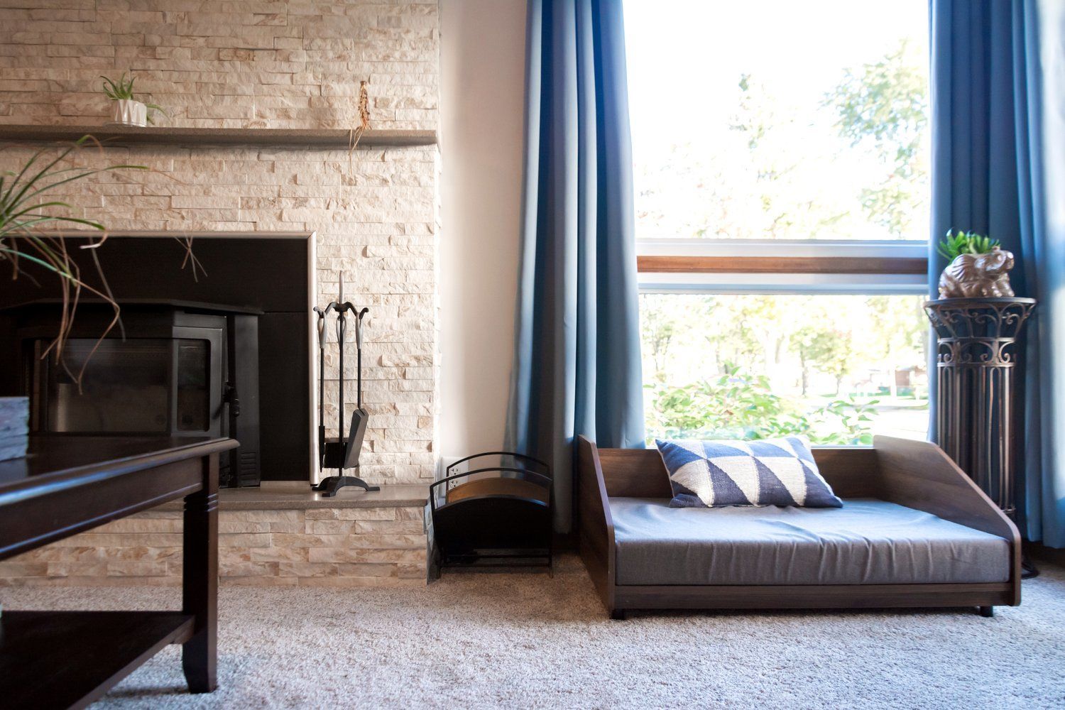 A living room with a fireplace and a dog bed.