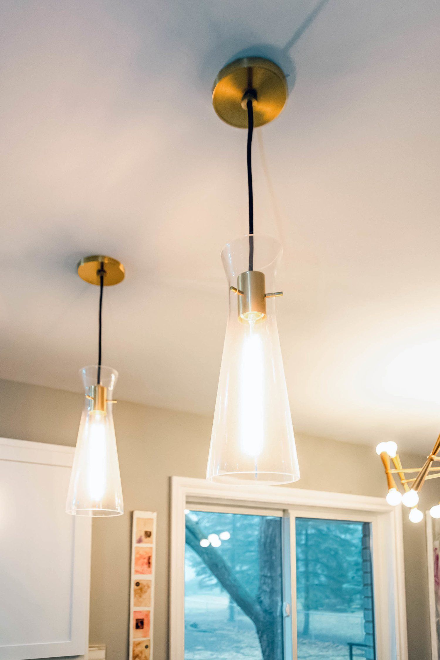 Two pendant lights are hanging from the ceiling in a kitchen.