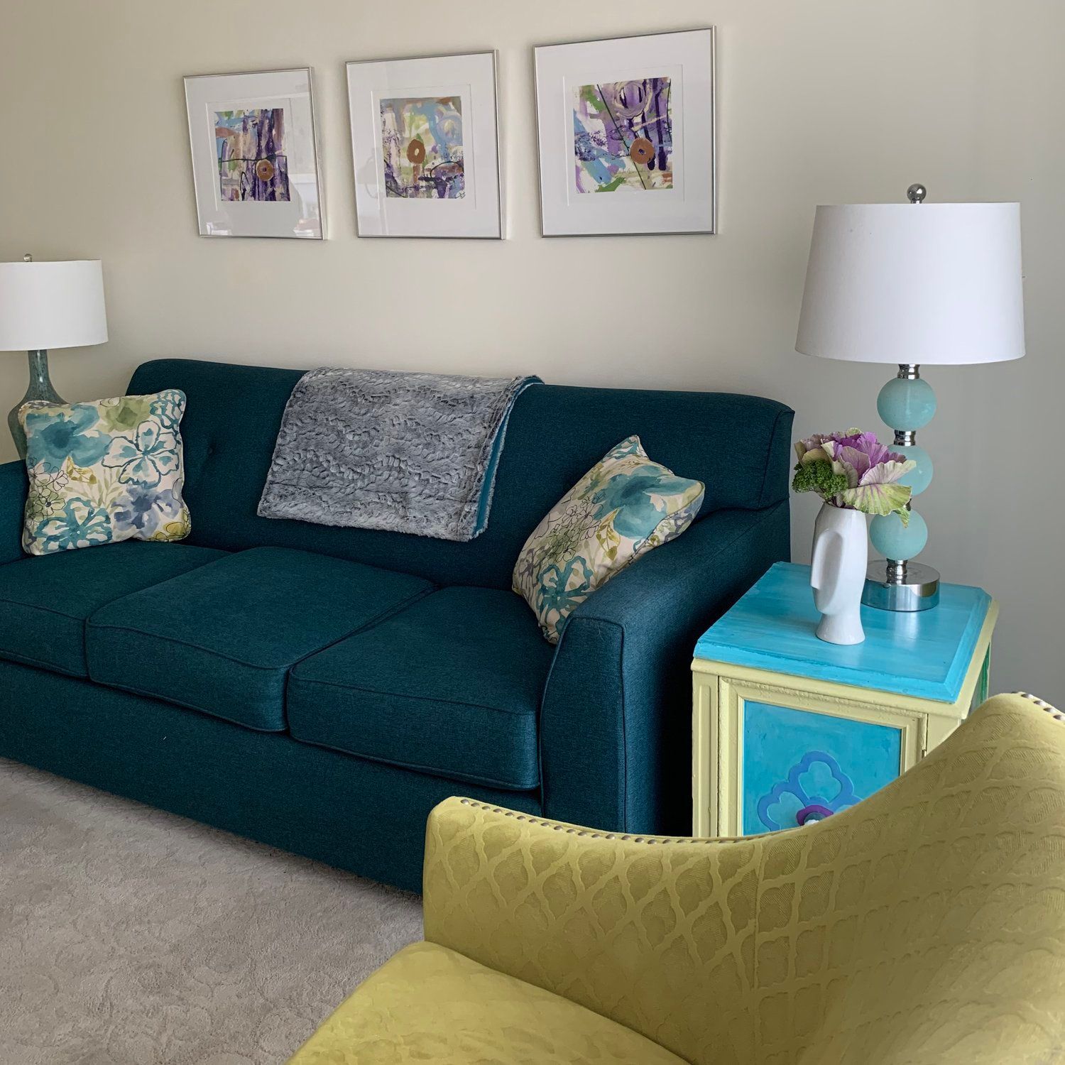 A living room with a blue couch and a yellow chair
