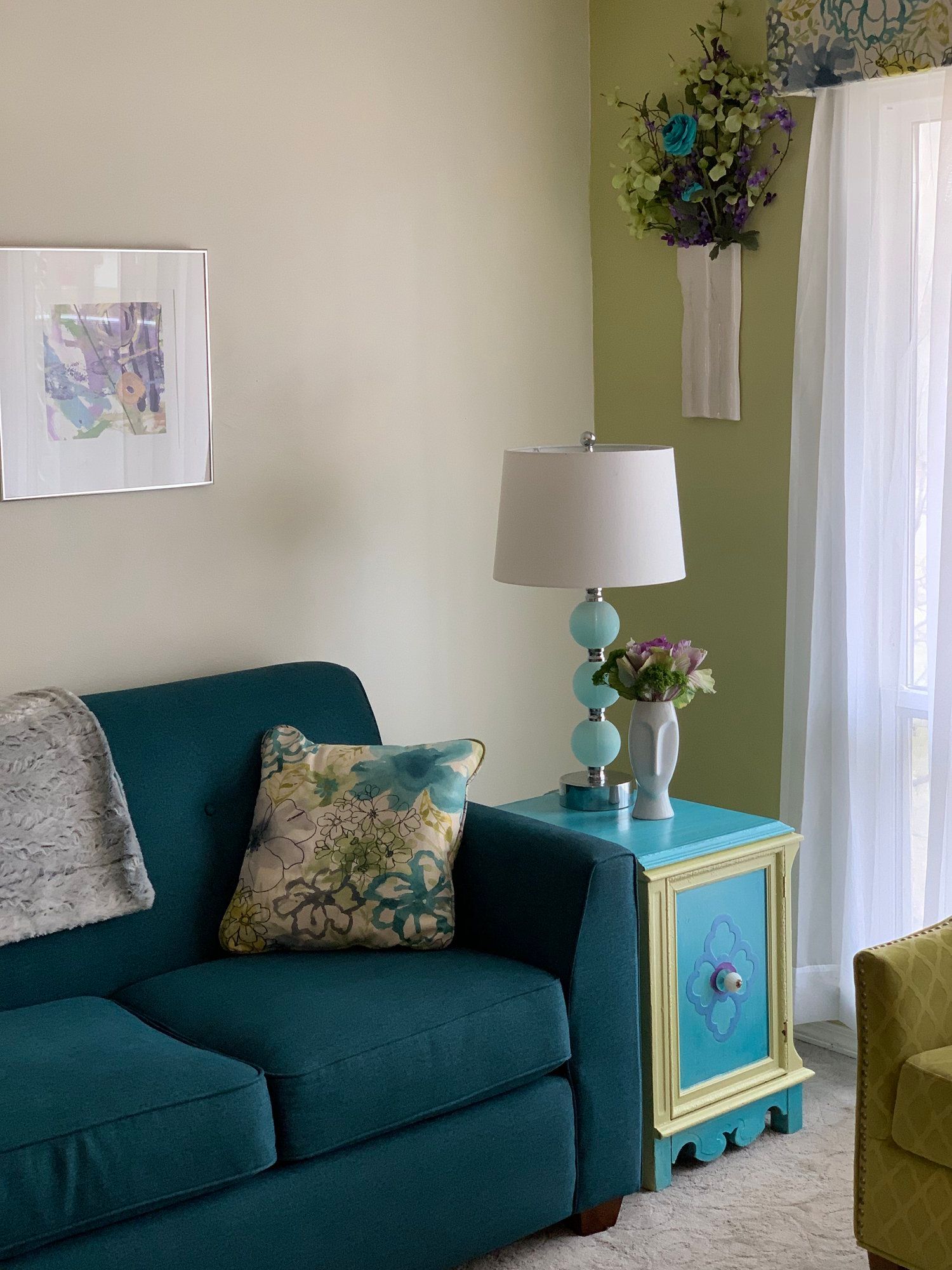 A living room with a blue couch and a lamp