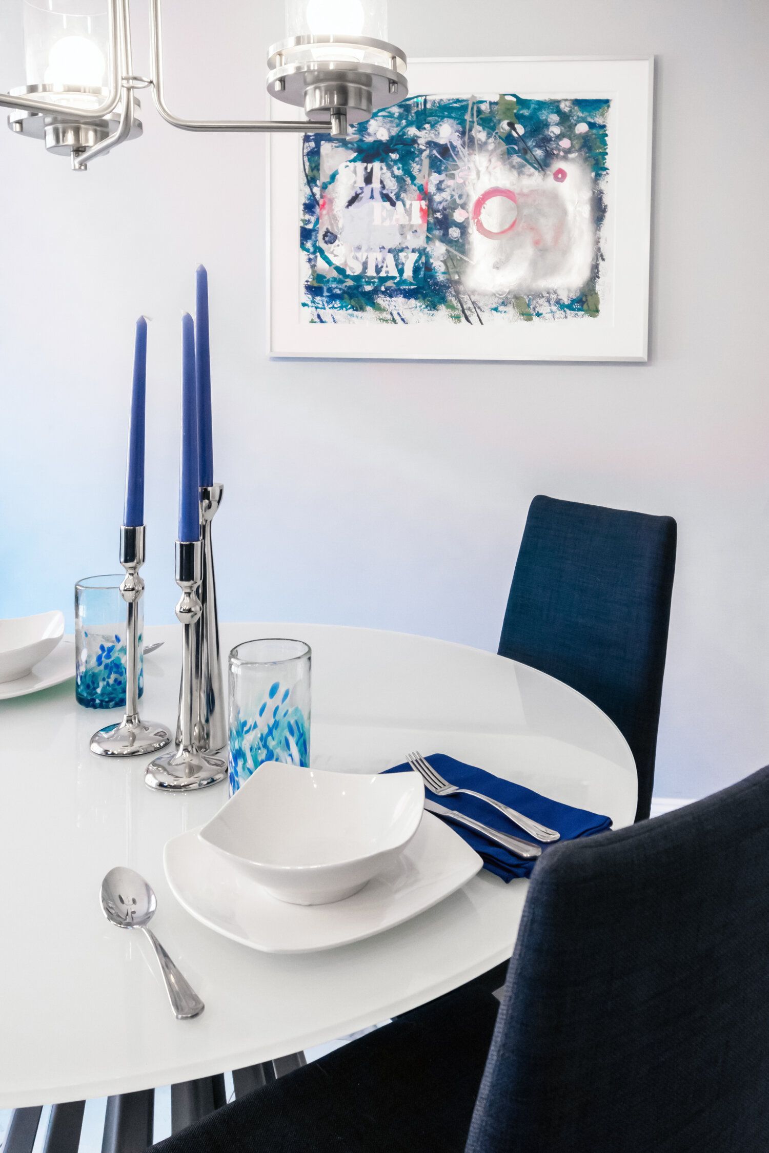 A dining room with a white table and blue chairs