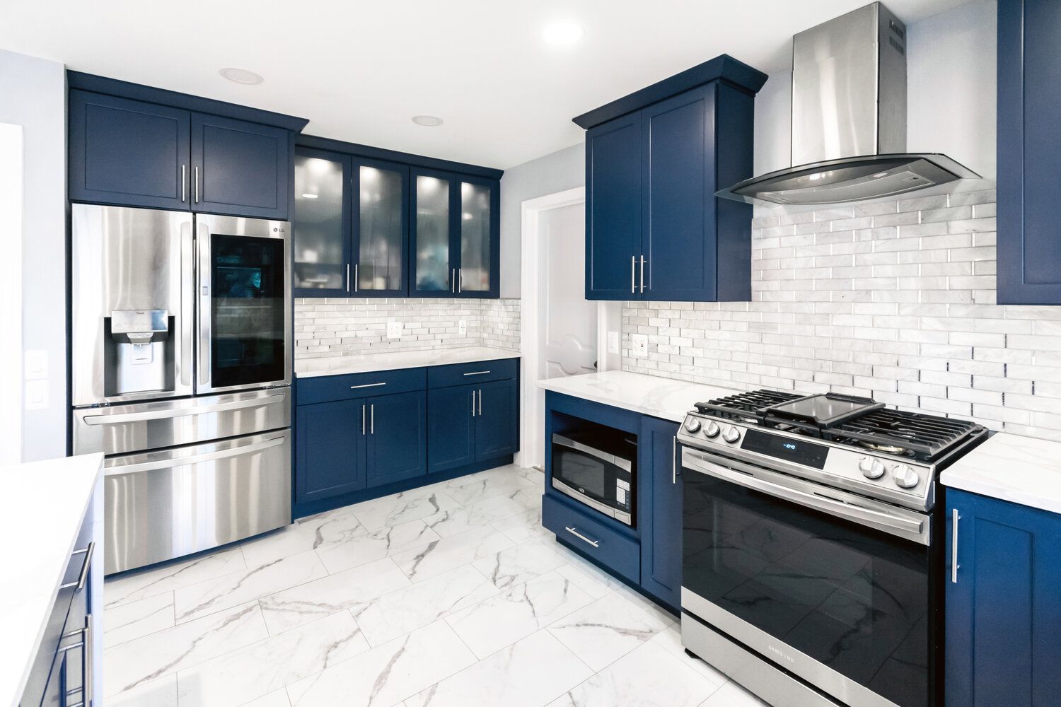 A kitchen with blue cabinets and stainless steel appliances.
