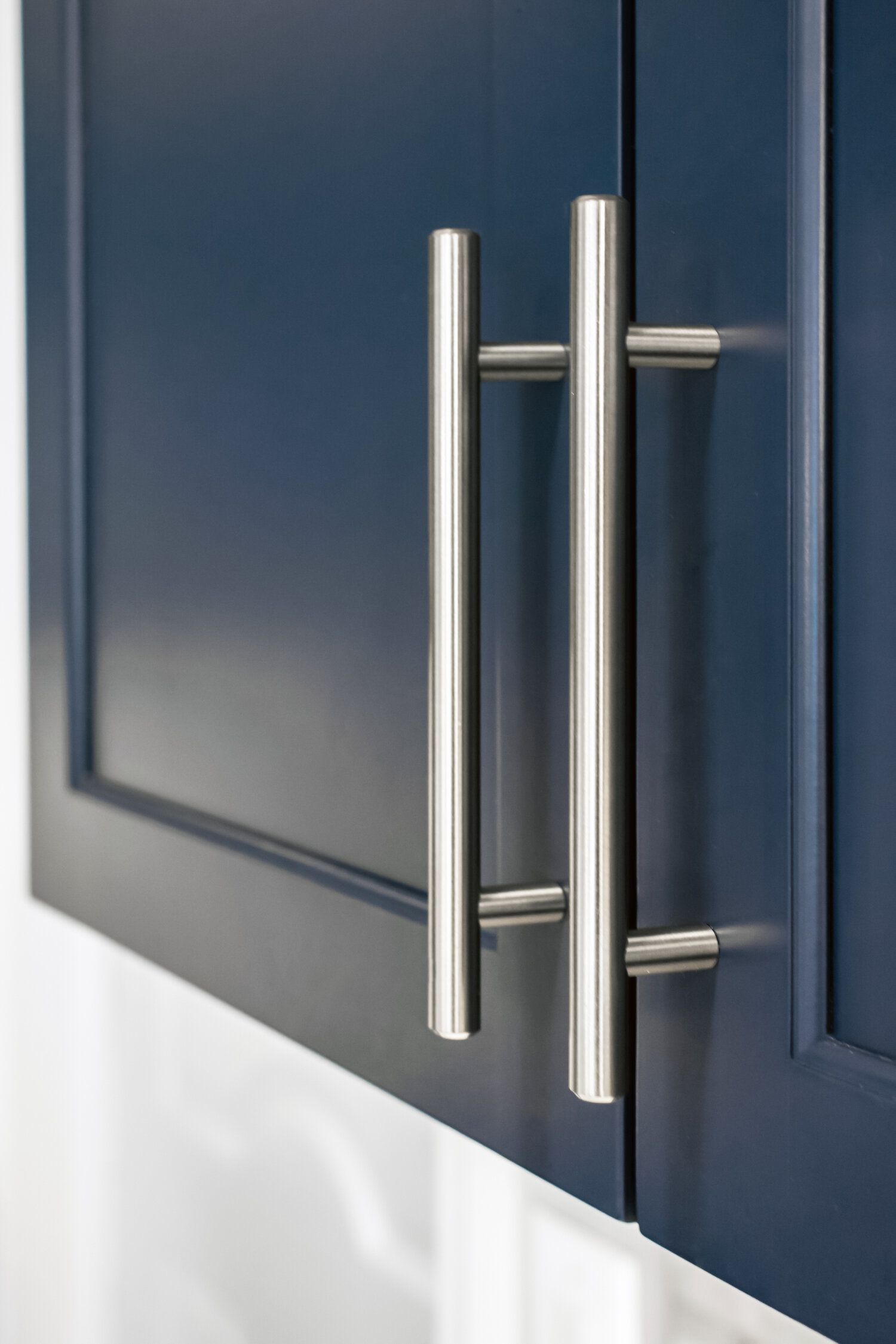A close up of a blue cabinet with stainless steel handles