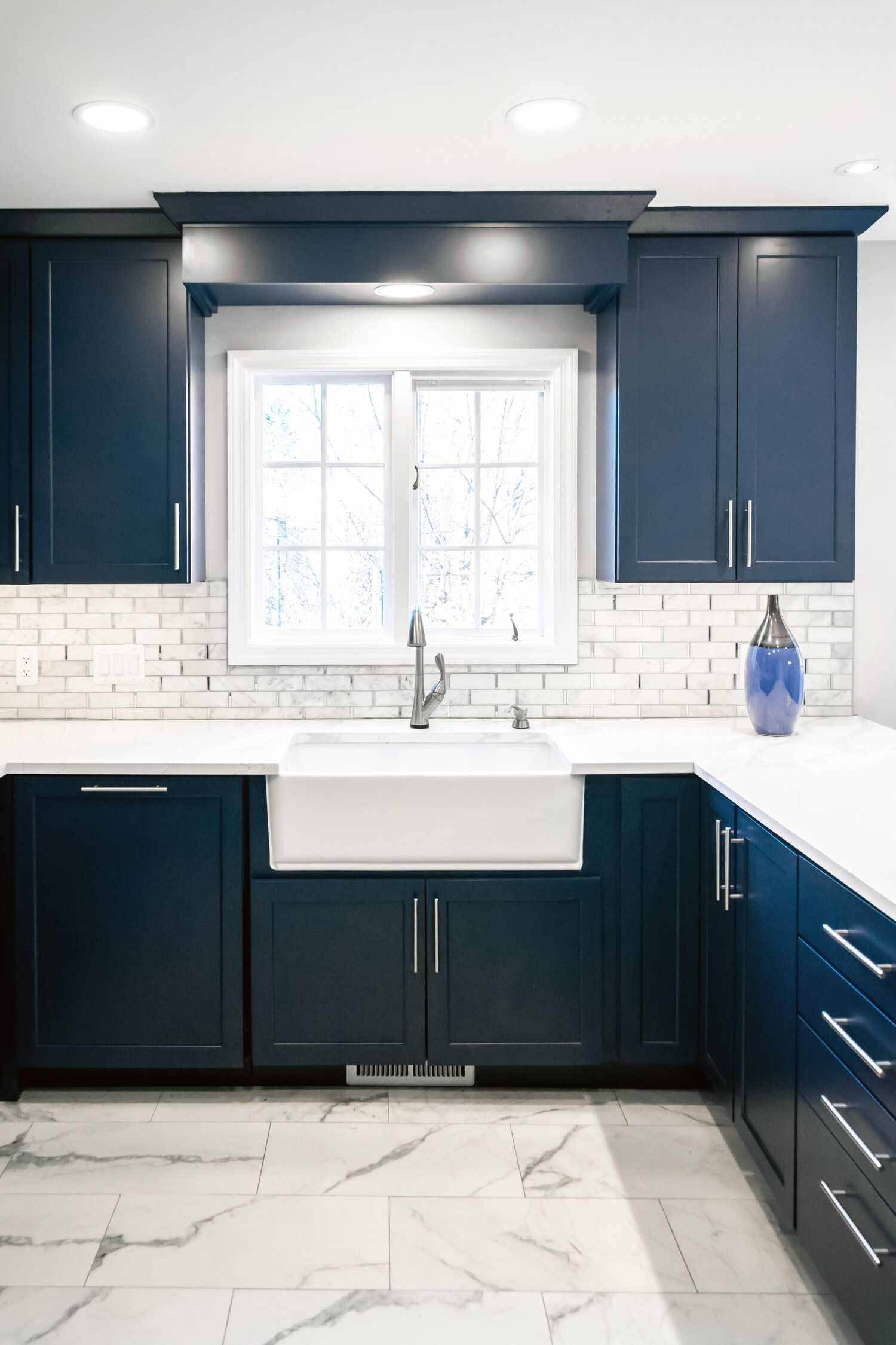 A kitchen with blue cabinets and a white sink